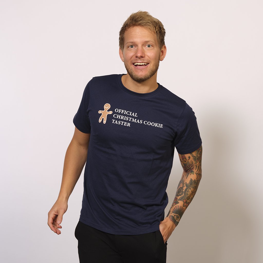 Un uomo sorridente che indossa una maglietta nera con un omino delle torte.